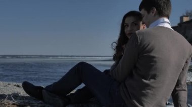 Date of a young couple on the river bank, in the background sun glare, sunny spring day