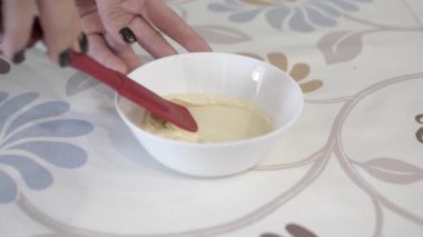 Çerçeveden çıkarılan kadın elleri çikolatalı beyaz bir bardak, yakın plan..
