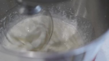 Profesyonel karıştırıcı, metal bardakta beyaz sıvıyı karıştırıyor, yakın plan..