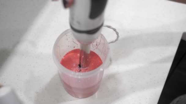 女性の手は 赤塗料 プラスチックシリンダー ブレンダー クローズアップとピンクの液体をミックスします — ストック動画