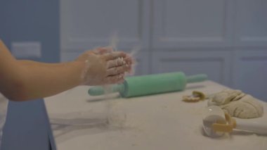 Çocukların elleri un ve hamurla oynuyor, beyaz mutfakta, yakın plan..