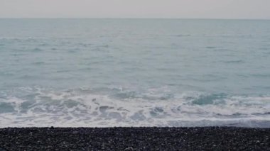 Güzel deniz manzarası, mavi su ve kayalık bir sahildeki dalgalardan gelen beyaz köpük..
