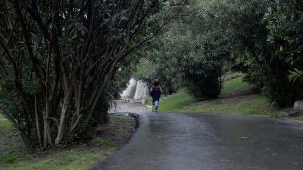 Ragazzo Corre Una Strada Bagnata Dalla Pioggia Parco Tropicale Lontananza — Video Stock