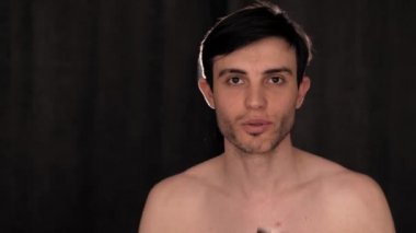 Beyaz adam siyah arka planda alüminyum sprey ile şaka yapıyor..