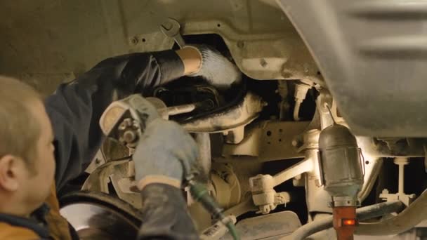 Azjata Naprawia Podwozie Starego Samochodu Podniesionego Windzie Warsztacie Zbliżenie — Wideo stockowe