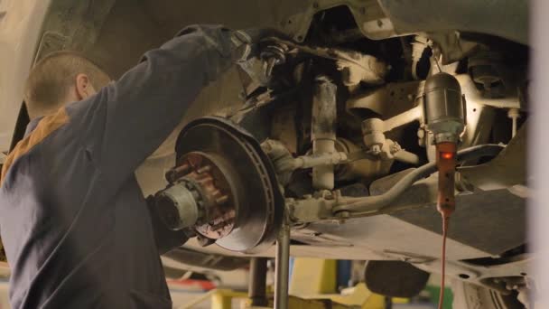 Een Aziatische Man Repareert Het Chassis Van Een Oude Auto — Stockvideo