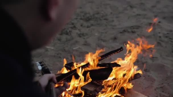 砂の中で燃える火を見てギターを弾く男 後ろからの眺め 夏の夜 スローモーション ロイヤリティフリーのストック動画