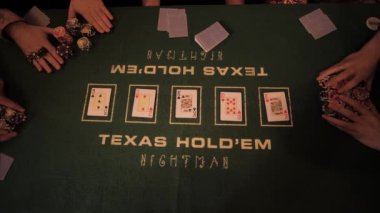 Erkek ve kadın elleri kumarhaneden masanın ortasına cips taşır ve onları iskambil kağıtlarıyla karıştırır. Yeşil masanın üzerinde. Yukarıdan görüntüle.