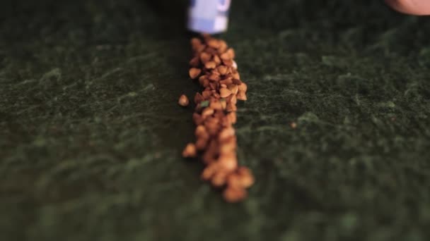 Banknottan Çıkan Bir Tüp Yeşil Bir Kumaş Üzerindeki Karabuğdayı Emiyor — Stok video