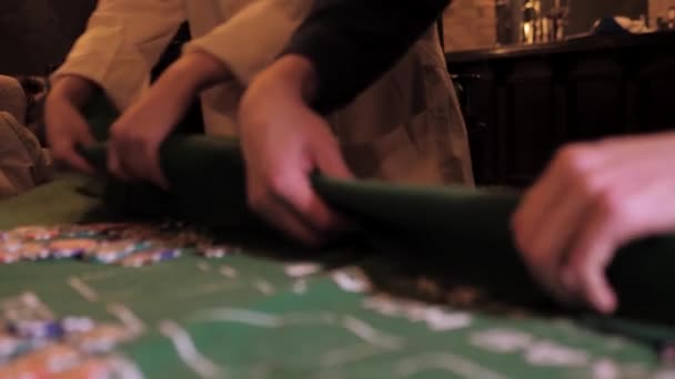 手のいくつかのペアは カジノのチップやそばの中に緑の布を折る — ストック動画