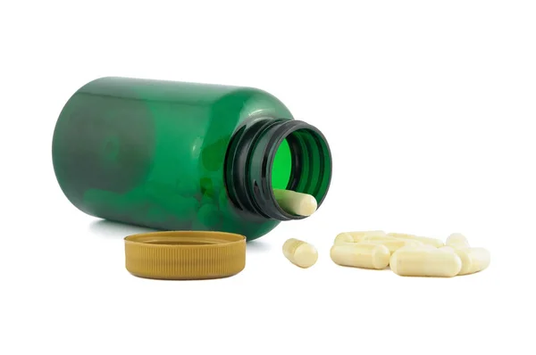 Pills falling out from green jar — Stock Photo, Image