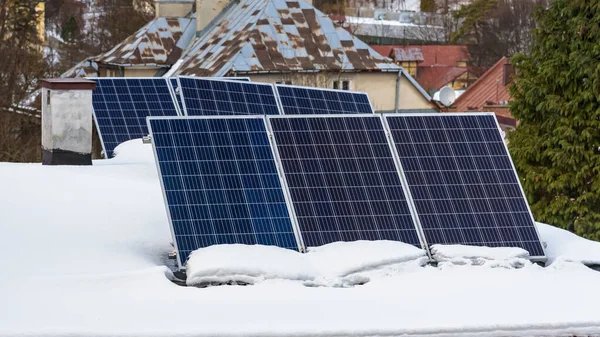 雪に覆われた屋根の上の太陽光発電所の太陽光パネル — ストック写真