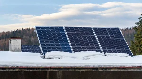 雪に覆われた屋根の上の太陽光発電所の太陽光パネル — ストック写真