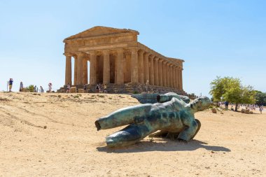 Agrigento, Italy - August 24, 2017: Sculpture of Icarus by Igor Mitoraj in front of the Concordia Temple in Valley of the Temples in Agrigento on Sicily clipart