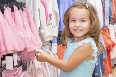 Alışveriş. Indirimler. küçük alışverişkolik kız. Bir kız kendine bir şeyler seçer, bir kız bir şeyler alır. alışveriş zevk. Alışveriş merkezi, alışveriş. Duyguları