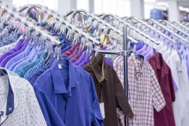 Giysiler bir rafta asılı. Gömlekli kumaş askıları. Erkek iş kıyafetleri. giyim süpermarketi