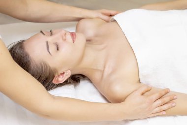Masaj ve vücut bakımı. Spa vücut masajcısı kadın el muamelesi yapıyor. Güzeller güzeli bir kız için masaj yaptıran bir kadın.