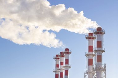Mavi gökyüzü arka planında fabrika bacası. Termal yoğunlaştırma santrali. Enerji üretimi ve hava kirliliği endüstriyel sahne