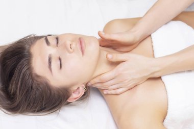 Servikal kaslara masaj ve gerdirme. Güzel bir kız spa salonunda masaj yaptırıyor. Açık tonlu fotoğraflar. Masaj ve sağlık konsepti. romatizma, artrosis