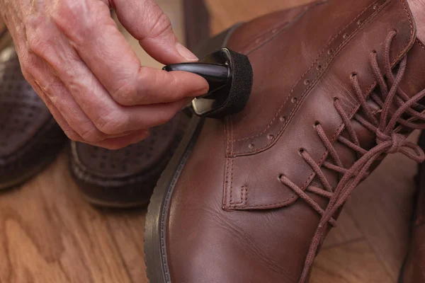 Leather shoe care. Applying shoe polish to brown shoes. Shabby leather brown shoes.