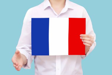 Fransa 'ya hoş geldiniz, nüfus göçü. Dünya. Elinde Fransa bayrağı olan mavi bir arka planda elini uzatan bir adam.