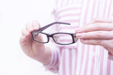 Karanlık çerçevede görüş düzeltme gözlüğü. Adam gözlük takıyor. hafif bir arka planda. yakın plan.