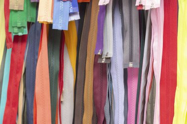 Fermuarların arka plan dokusu. Bir sürü farklı renkte fermuar. Elbise dikme, atölye, kumaş ve aksesuar dükkanı..