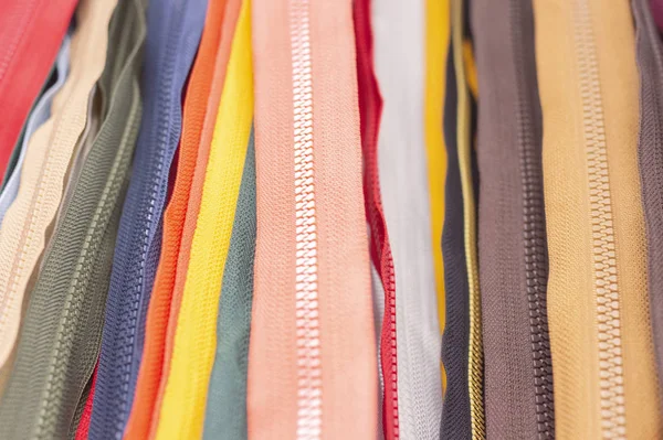 Fermuarların arka plan dokusu. Bir sürü farklı renkte fermuar. Elbise dikme, atölye, kumaş ve aksesuar dükkanı..