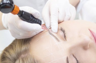 Makyaj malzemesi. Güzellik Uzmanı Elleri Kadın Yüzünde Kaş Dövmesi Yapıyor. Güzellik Salonunda Kalıcı Oral Makyaj. 