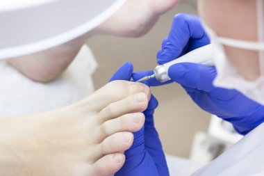 Terapi pedikürü. Usta podolojist donanım pedikürü yapıyor. Podiyatriyi ziyaret et. Kaplıcada ayak tedavisi. Podiatria Kliniği.