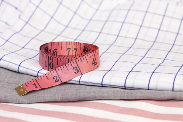 measuring tape is on cotton fabric. sewing concept, sewing from natural fabrics.
