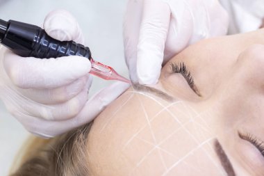 Makyaj malzemesi. Güzellik Uzmanı Elleri Kadın Yüzünde Kaş Dövmesi Yapıyor. Güzellik Salonunda Kalıcı Oral Makyaj. 