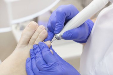 Terapi pedikürü. Usta podolojist donanım pedikürü yapıyor. Podiyatriyi ziyaret et. Kaplıcada ayak tedavisi. Podiatria Kliniği.