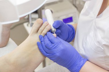 Terapi pedikürü. Usta podolojist donanım pedikürü yapıyor. Podiyatriyi ziyaret et. Kaplıcada ayak tedavisi. Podiatria Kliniği.