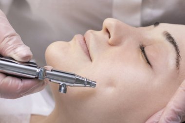 Oksijen mezoterapisi. Aquapilling. Kozmetik soyma prosedürü. Güzellik salonundaki genç bir kız için enjeksiyonsuz mezoterapi..