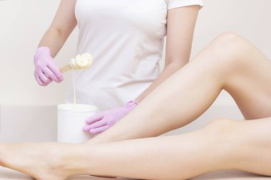 Şekerleme. Şekerli krema. Kuaförde bacak aldırma prosedürü olan bir kadın. Yasaklama kavramı