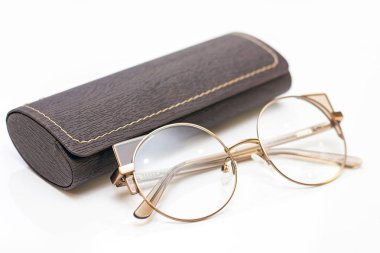 Modern moda kadınlar için altın gözlük ve açık arkaplanda deri bir çanta..