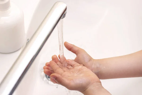 children's hands are washed. children's hands in foam from antibacterial soap. Protection against bacteria, coronavirus. hand hygiene. hand washing with water
