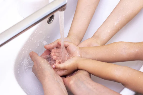 大人も子供も手を洗う 抗菌石鹸から泡を手に入れます コロナウイルスからの保護 手の衛生だ 手を水で洗う 多くの手 — ストック写真