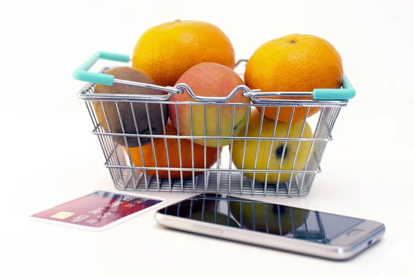 ordering food at home in connection with isolation from the coronavirus. phone and card. fruits in the basket.
