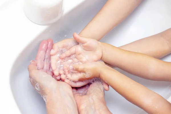 adults and children wash their hands. hands in foam from antibacterial soap. Protection against bacteria, coronavirus. hand hygiene. washing hands with water. many hands