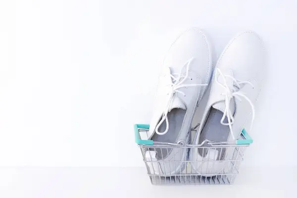 Beyaz Arka Planda Alışveriş Sepetinde Beyaz Yeni Ayakkabılar — Stok fotoğraf