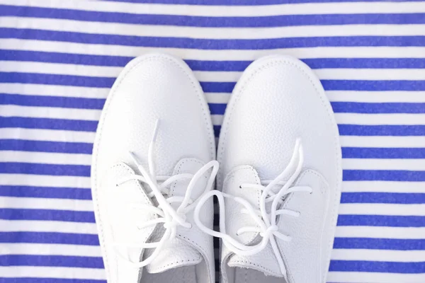 縞模様の白 青の背景に白いスニッカー トップビュー — ストック写真