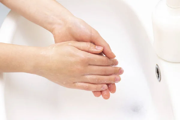 man washes his hands. hands in foam of antibacterial soap. Protection against bacteria, coronaviruses. hand hygiene. wash hands with water. many hands