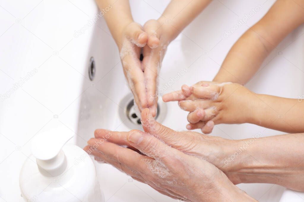 adults and children wash their hands. hands in foam from antibacterial soap. Protection against bacteria, coronavirus. hand hygiene. washing hands with water. many hands