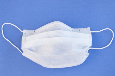 Mavi arka planda tıbbi koruyucu maske. Coronavirus, Salgın, Evde Kalın, Güvende Kalın
