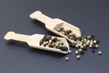 Siyah bir arka planda ahşap kaşıkta biberli mısır. Karanlık arka plan. yemek konsepti