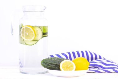 Sağlık hizmeti, fitness, sağlıklı beslenme konsepti. Taze soğuk limon salatalığı suyu, kokteyl, detoks içeceği, bardakta limonata ve bardakta. Bir tabakta salatalık ve limon