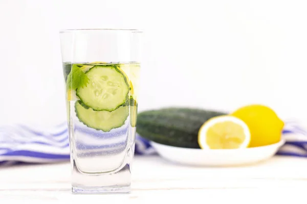 Health care, fitness, healthy eating concept. Fresh cool lemon cucumber drink with water, cocktail, detox drink, lemonade in a glass jug and a glass.