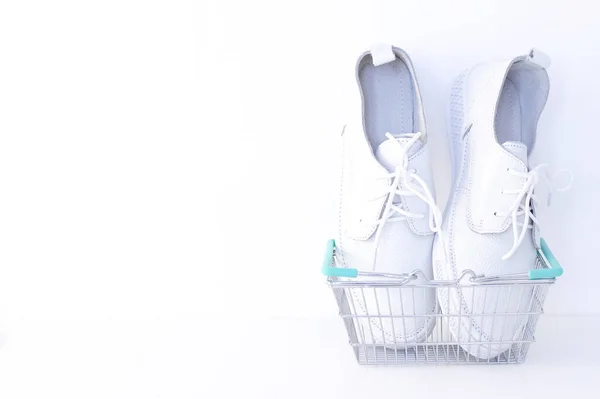 Beyaz Arka Planda Alışveriş Sepetinde Yeni Beyaz Ayakkabılar Kopyalama Alanı — Stok fotoğraf
